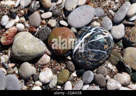 Variety of colorful, small pebbles and stones on the shoreline of the Mediterranean sea in Greece. Stock Photo