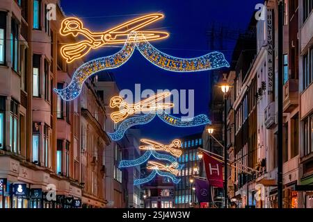 Christmas lights in the form of tailors scissors above Savile Row ,a street known for high end tailoring in Mayfair, London W1 Stock Photo