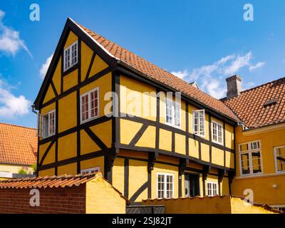 Half-timbered yellow two-storey house with red-tiled roof in old town of Svendborg on Funen Island, Southern Denmark Stock Photo