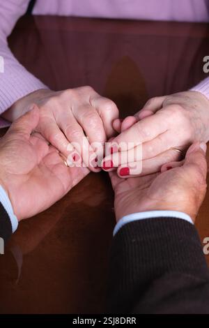 Elderly couple holding hands with love and affection Stock Photo