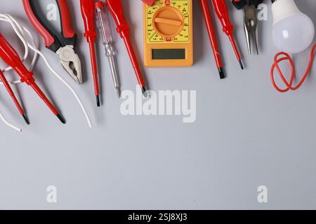 Different electrical tools on grey background, flat lay. Space for text Stock Photo