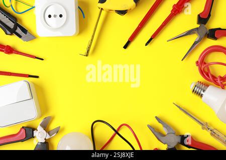 Frame of different electrical tools on yellow background, flat lay. Space for text Stock Photo