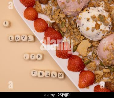 A plate of ice cream scoops with strawberries and granola for ice cream for breakfast day Stock Photo