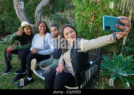 Friends taking selfie on bench Stock Photo