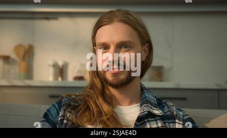 Portrait happy smiling laughing positive joyful funny Caucasian bearded man guy male at home couch sofa laugh smile joke fun joy humorous relax at Stock Photo