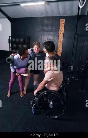 Smiling friends embracing in yoga studio Stock Photo