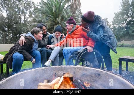 Friends by fire pit in garden Stock Photo
