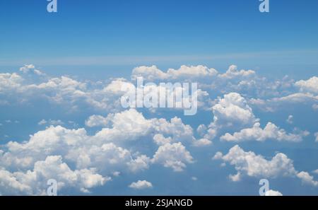 White clouds floating in the sky view from airplane while flying over the sea of clouds Stock Photo