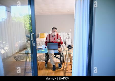Man in wheelchair using smart phone Stock Photo