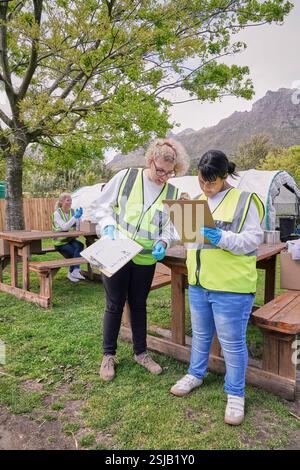 Two female volunteers checking list during packaging donation boxes Stock Photo