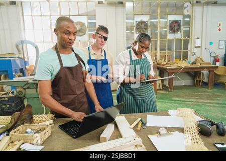 Group of craftsmen working in woodshop Stock Photo