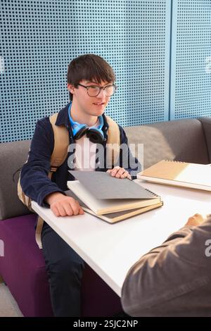 Man with Down Syndrome sitting at table Stock Photo