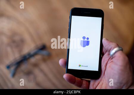 A mobile phone being held showing the Microsoft Teams app open on screen. Photo credit: SMP News Stock Photo