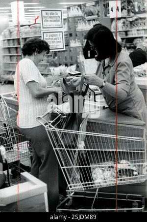 --- Olten, Migros Kassiererin durchsucht Tasche einer Kundin, 1974#Olten, Migros cashier searching shopping bag of a customer, 1974- RDB BY DUKAS Stock Photo