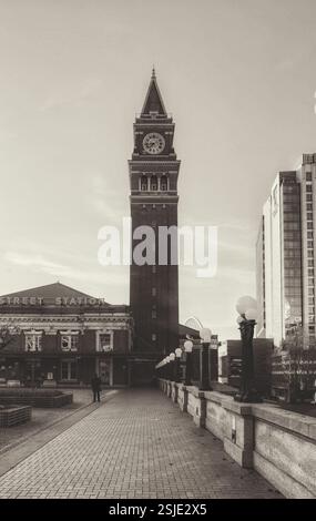 A brick train station at King Street in Seattle, Washington, with a tall clock tower stands proudly against a clear sky. Stock Photo