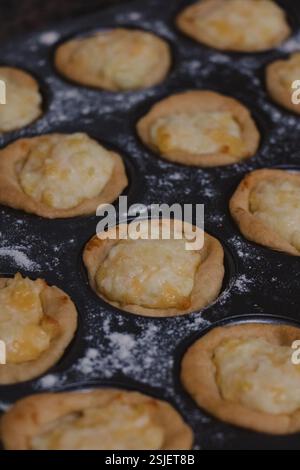 Baking Cheese quiches in Muffin Tray Stock Photo