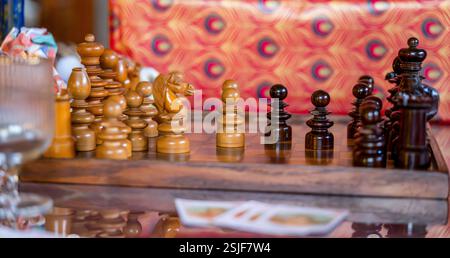 Handcrafted Wooden Chess Pieces on Rustic Chessboard with Festive Vibrant Background Stock Photo