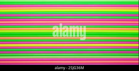 Colored plastic straws or tubes with blue, orange, pink, yellow and green stripes. Abstract background. Stock Photo
