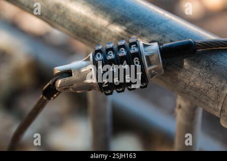 A bicycle combination cable lock secures a bike to a bicycle rack to prevent it from being stolen. Stock Photo