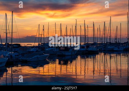 Colorful sunset over the marina of Koper, Slovenia, with all the boats reflecting on the water Stock Photo