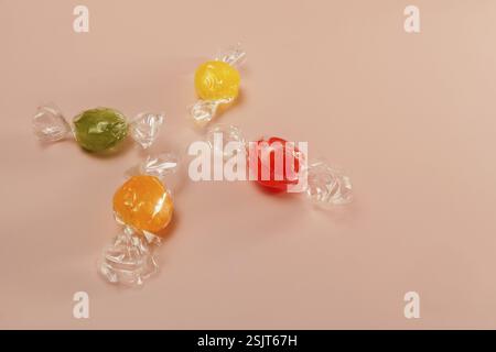 Colored candies wrapped in cellophane paper isolated on a pink background and copy space Stock Photo