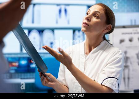 Doctors and nurses analyze human anatomy scans results in a treatment center, putting the right diagnosis. Diverse team of healthcare experts working together on disease prevention, x ray tests. Stock Photo