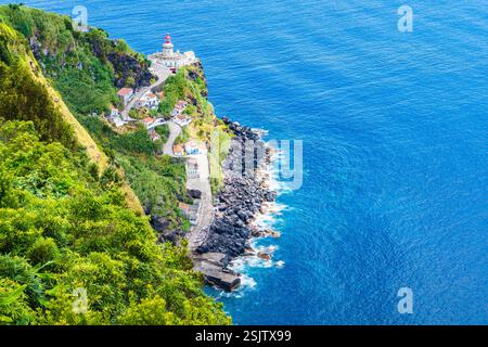 View of lighthouse against blue water on ocean coast Farol do Arnel, Sao Miguel island, Azores, Portugal Stock Photo