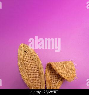 Bunny rabbit ears made of natural plants material on pastel purple background. Easter minimal concept. Flat lay. Stock Photo