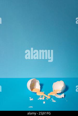 Eggshell with pastel pink paint. Creative copy space on blue background. Minimal Easter holiday concept. Stock Photo