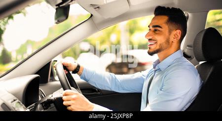 Joyful arabic guy driving nice auto, side view Stock Photo