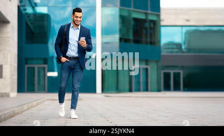 Confident arabic guy programmer with backpack walking by street Stock Photo