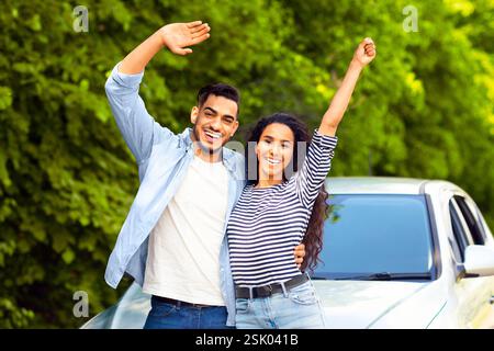Emotional multiracial couple standing by nice auto Stock Photo