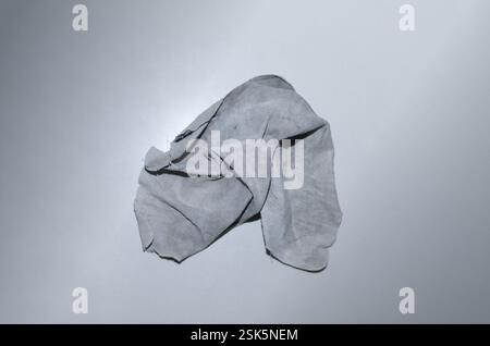 Crumpled Gray Cloth with human face silhouette on a Neutral Gray Background Stock Photo