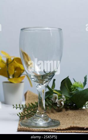 Empty Glass Goblet on Rustic Table with Floral and Botanical Elements Stock Photo