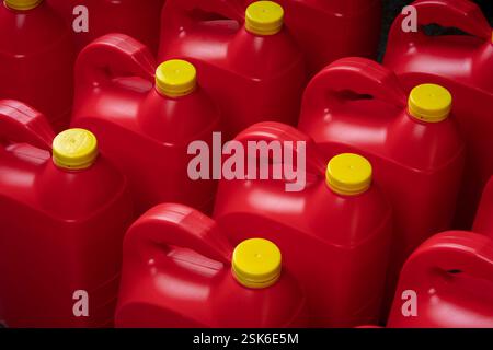 Top view texture of neat red plastic motor oil bottles, containers with handle and yellow screw cap without label Stock Photo