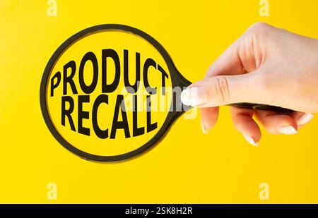 Product recall symbol. Concept words Product recall on magnifying glass. Beautiful yellow background. Businessman hand. Business and Product recall co Stock Photo