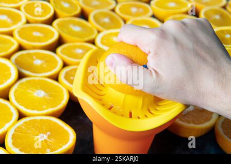 the process of squeezing juice with your hands from citrus fruits close up Stock Photo