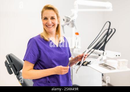 Portrait of happy dentist in her dentist's office. Confident adult woman working in a dental clinic. Stock Photo