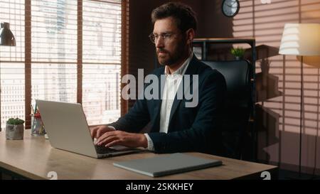 Serious concentrated working online internet job work Caucasian middle-aged business man adult businessman guy male employer entrepreneur in office Stock Photo