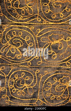 Old fabric in golden tones with handmade embroidery, can be used as a background or to add textures, vintage. Pattern in warm dark blue tones. Stock Photo
