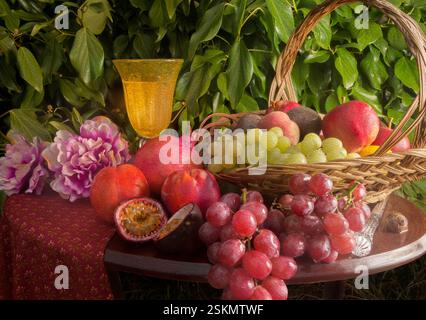 A collection of fruits and peony flowers with an ivy background. Stock Photo