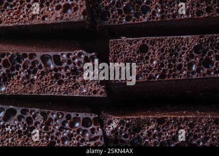 Macro photo of porous airy dark chocolate with rich texture. Detailed air bubbles, deep chocolate color, close-up, contrasting light. Perfect for food Stock Photo