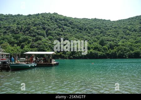 Floating seafood farm with boats on a turquoise lake Stock Photo
