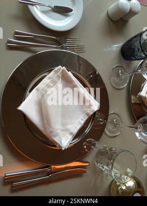Immaculate table setting in Braga, Portugal. Pristine white napkins, gleaming silverware, and crystal glassware adorn the table, anticipating a refine Stock Photo