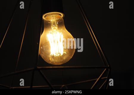 close-up in a edison light bulb with yellow light and some dust arount it Stock Photo