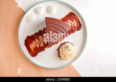 Three layered chocolate cake with cream and gelato scoop top angle shot. Stock Photo