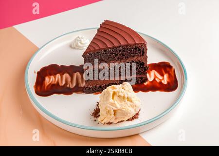 Three layered chocolate cake with cream and gelato scoop. Stock Photo