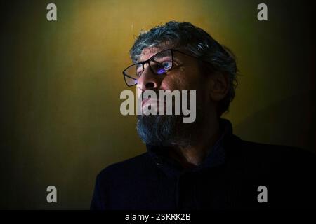 Expressive portrait of a middle-aged man, wearing glasses, with a worried and interested expression on his face. Stock Photo