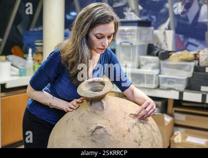 London, UK. 12th Feb, 2025. EMBARGOED until 0.01am Thursday 13th Feb. Curator Kate Sumnall examines a Roman Spanish Amphora found in the River Thames. Mudlarked finds discovered in the River thames are being prepared at the London Museum's lab (the former Museum of London). The items are being prepared to go on display at London Museum Dockland's upcoming exhibition 'Secrets of the Thames: Mudlarking London's lost treasures'. Credit: Imageplotter/Alamy Live News Stock Photo