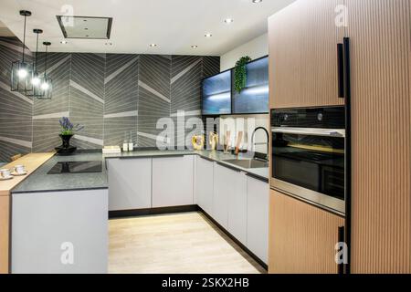 Modern and stylish kitchen interior featuring an island, sleek cabinets, and integrated appliances, creating a sophisticated culinary space Stock Photo